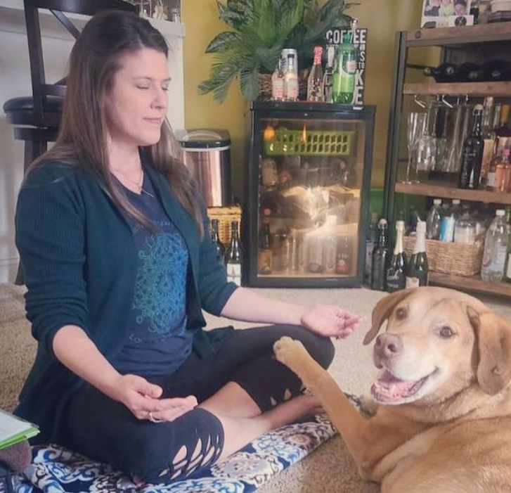 woman offering reiki to a dog